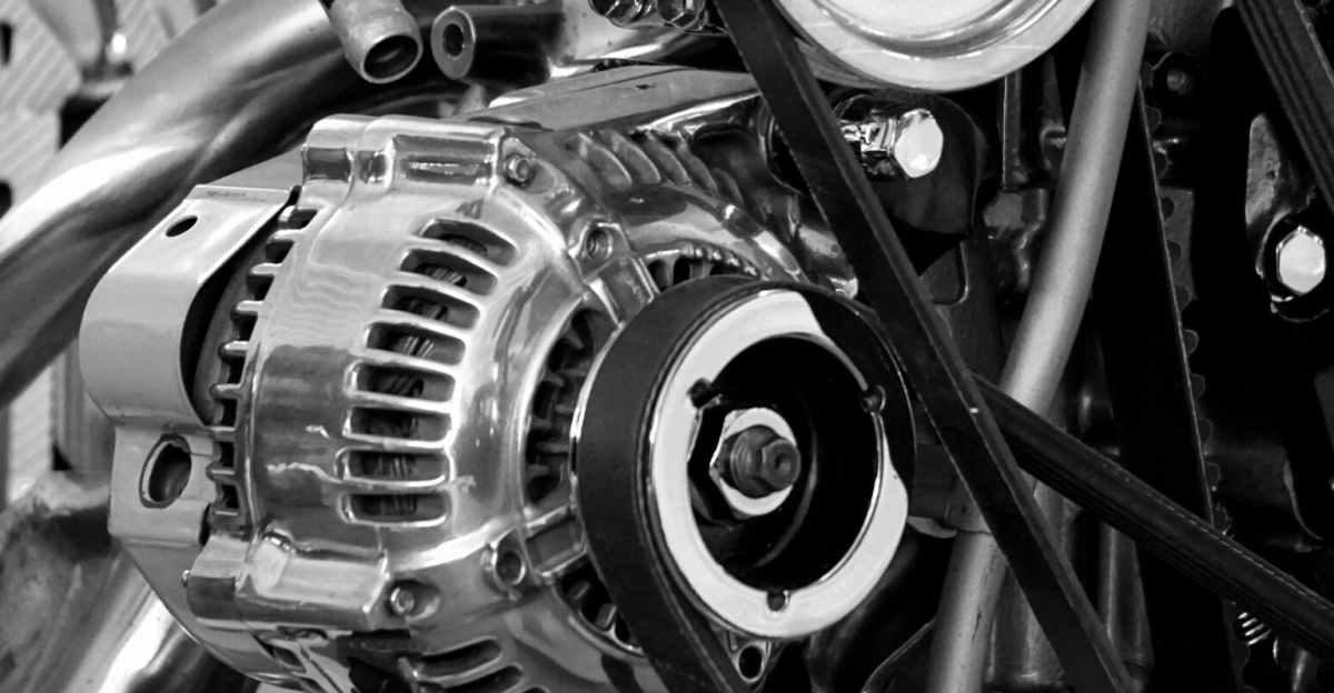 Close-up of a shiny car engine showing polished metal parts and gears in black and white.
