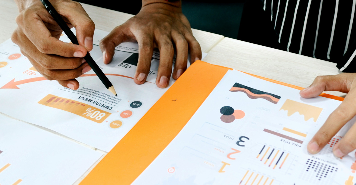person in blue shirt writing on white paper