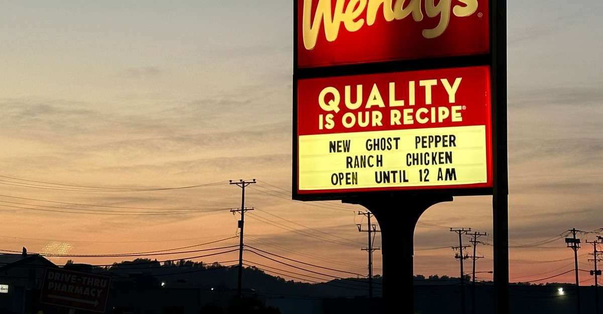 a sign for wendy s restaurant in a parking lot