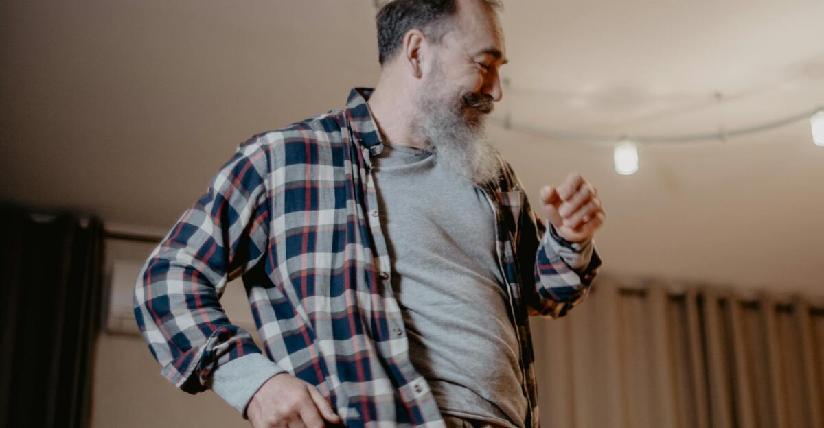 Senior man joyfully dancing indoors showing happiness and vitality