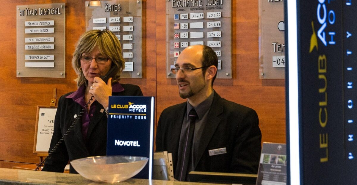 reception hotel desk interior design architecture corporate lobby help check in people laugh entrance hall input range key counter registration bell jar leisure time booking to travel business service call tourism women men s suit make a phone call phone check in check in check in check in check in