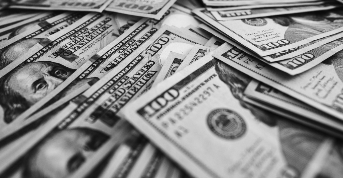 Monochrome image of scattered US hundred dollar bills representing wealth and prosperity.