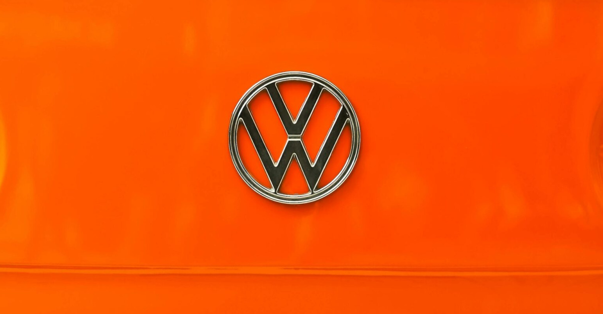 Close-up of a vintage Volkswagen van's front emblem with bright orange color and classic design.