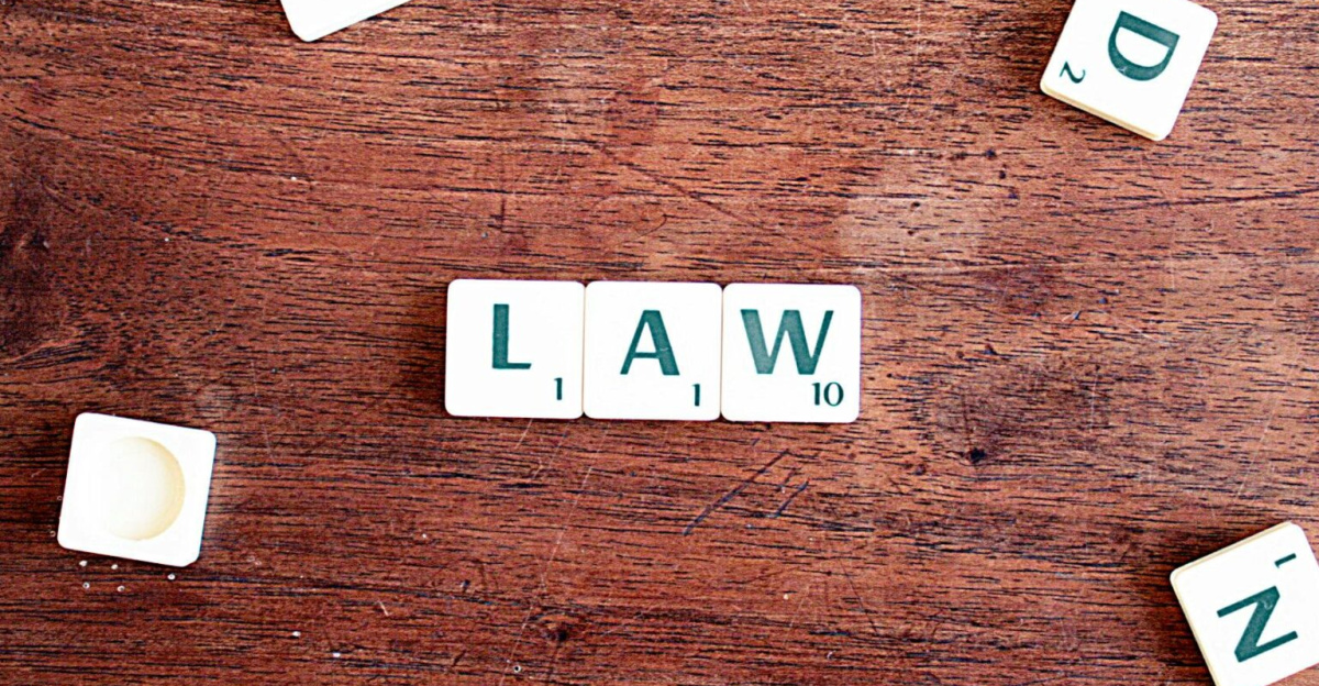 Scrabble tiles spelling 'LAW' on a wooden table, symbolizing connections to education and legality.