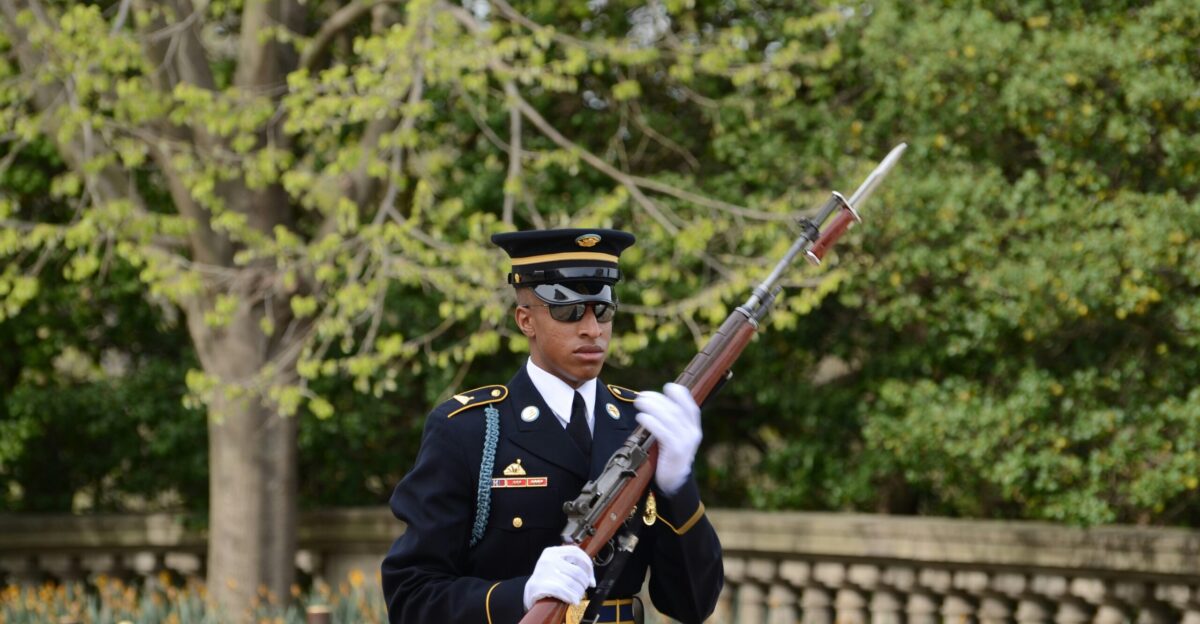 man in black and brown camouflage uniform holding rifle