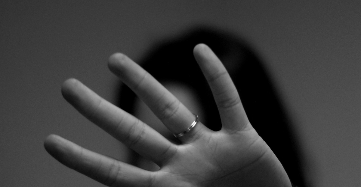 woman showing left hand with wedding band